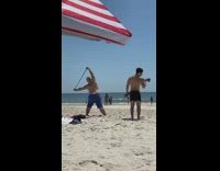 Collab Kook Of The Day - Two guys exercise beach sand resistance band 
