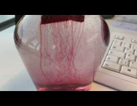 Red liquid descend from tea bag jar