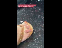 Woman wears brown sandals and has crooked short toe on subway train