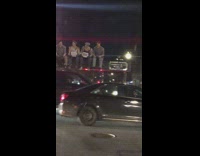 Men sit on metal beam in trunk of car, lunch atop skyscraper 