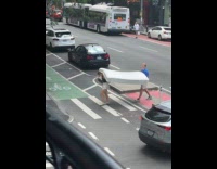 Collab WINY - Man and woman cross the street carry mattress