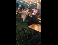 Guy holds camera phone photographs girl restaurant 