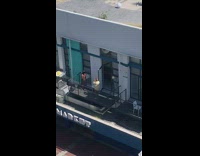 Woman in see thru dress poses at the balcony