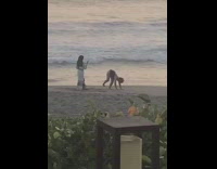 White shirt guy helps girl lift leg