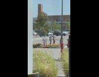 Two girls dance beside tree parking lot
