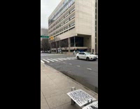 Guy walking off on sidewalk with a street sign