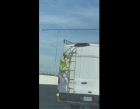 Dressed up skeleton figure decoration on the back of a moving van on freeway