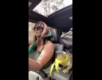 Girl driving car with frog sunglasses and scarf in passenger seat 