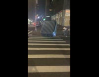 Guy carries big air mattress across the street 