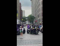 Man purple track suit dances in front of cart