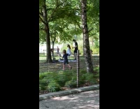 Guy cuts hair girl park white cape 