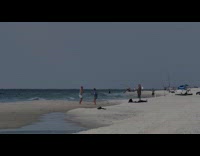 Two men sword fight beach sundown