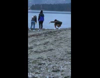 Man crouch films woman picks up dog poop