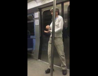 Man white jacket dances sensually to music on headphones on metro train