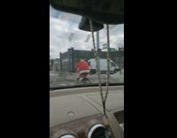 Guy wearing santa suit rides bicycle down street 