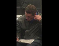 Guy green jacket subway notebook cleaning ears pen
