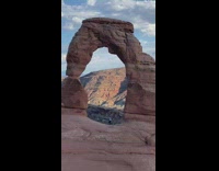 Woman performs with three hula-hoop under the rock arch
