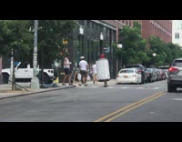 Guy dresses up as graffiti can and skateboards on the street with friend