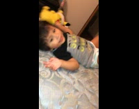 Little boy on bed hit in face with mickey toy runs into wall