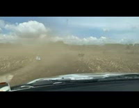 Cars driving through dirt field