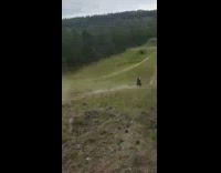 Guy jumps white dirt bike grass hill 