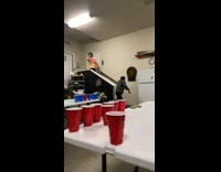 Guy hits a difficult beer pong shot from far on top of a staircase