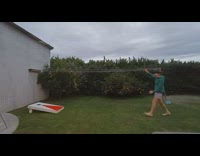 Boy lands ball after throwing it backwards into hole 