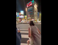Woman taking photos at shibuya crossing
