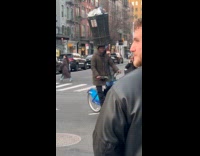 Man circling on bike with trash bin on head 