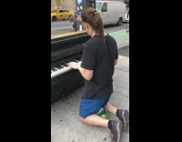 Guy kneeling on both knees playing on abandoned piano on sidewalk