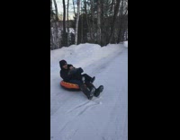 Dad son sled down snow in tube