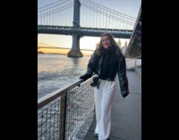 Woman pose beside fence splashed by water