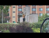 Man intimately caressing statue in park