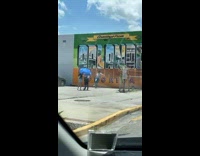 Man tiktok dance in front of Orlando California Graffiti Wall