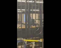 Person walking in subway station while wearing stilts under outfit 
