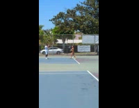 Woman in black bikini poses with a tennis racket