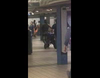 Guy walks black motorcycle through subway station 