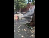Car in front of broken fire hydrant