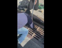 Guy tries to fish airpod out from storm drain with pole