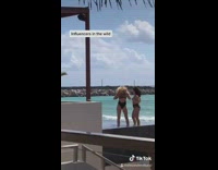 Two girls pose together beach shore resort