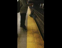 Homeless man sits on edge of subway platform, oncoming train almost runs him over and honks at him to move out of the way