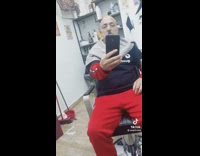 Bald guy with mustache films himself at barber shop