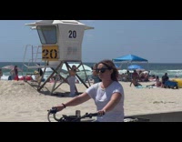 Woman in orange bra poses at the lifeguard house