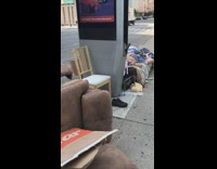 two people asleep on mattress on street