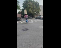 Guy bikes with luggage on head 