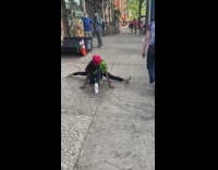 Lady does splits and push up at the same time on sidewalk 