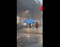 Women use blue beach umbrella during rain