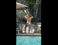 Blue white striped bikini girl poses pool 