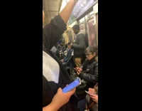 Man pets and holds kitten against chest on subway train