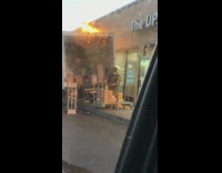 Guy throws packages boxes white UPS truck 